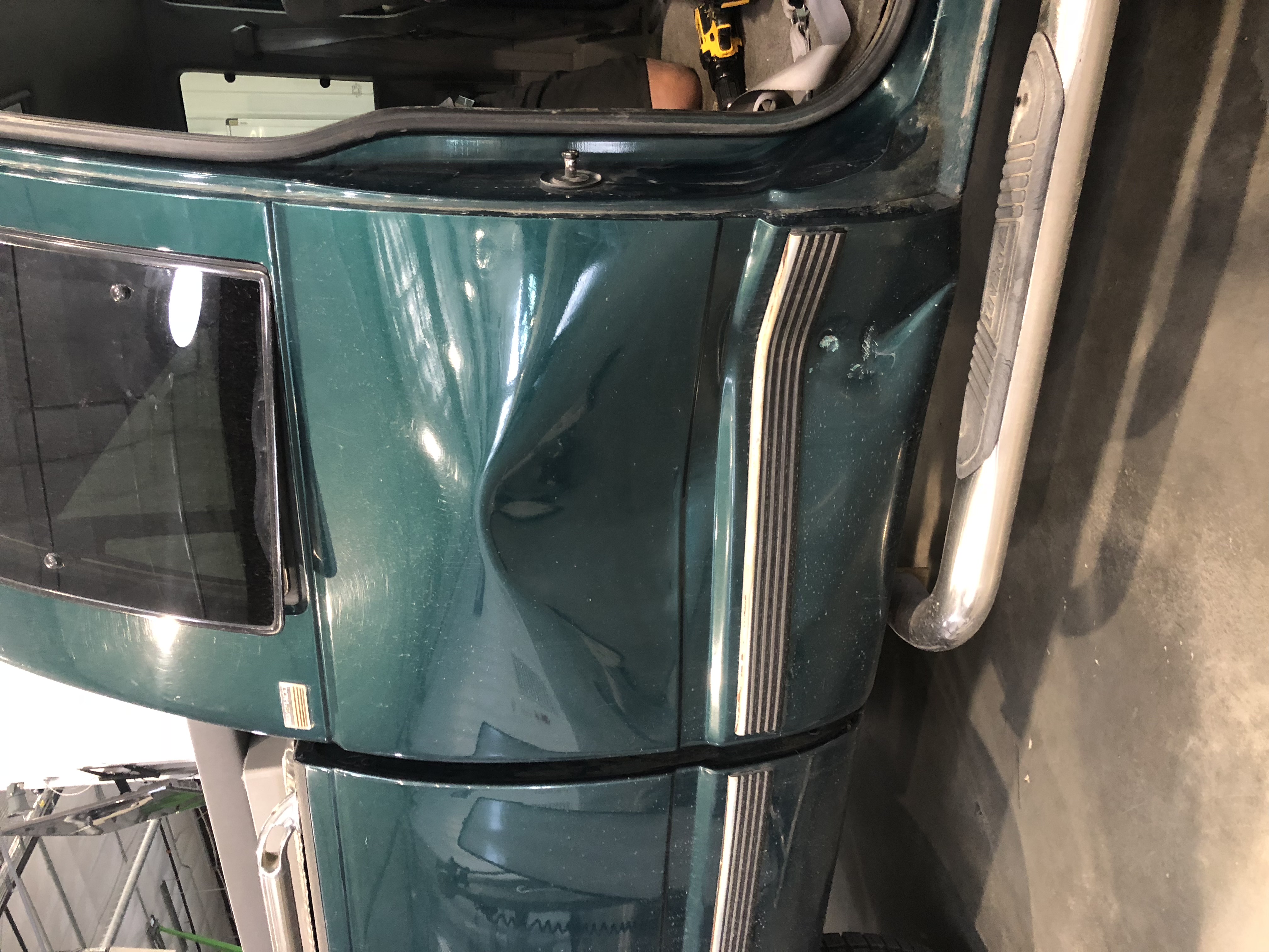 Before PDR — green SUV, severe dent near rear